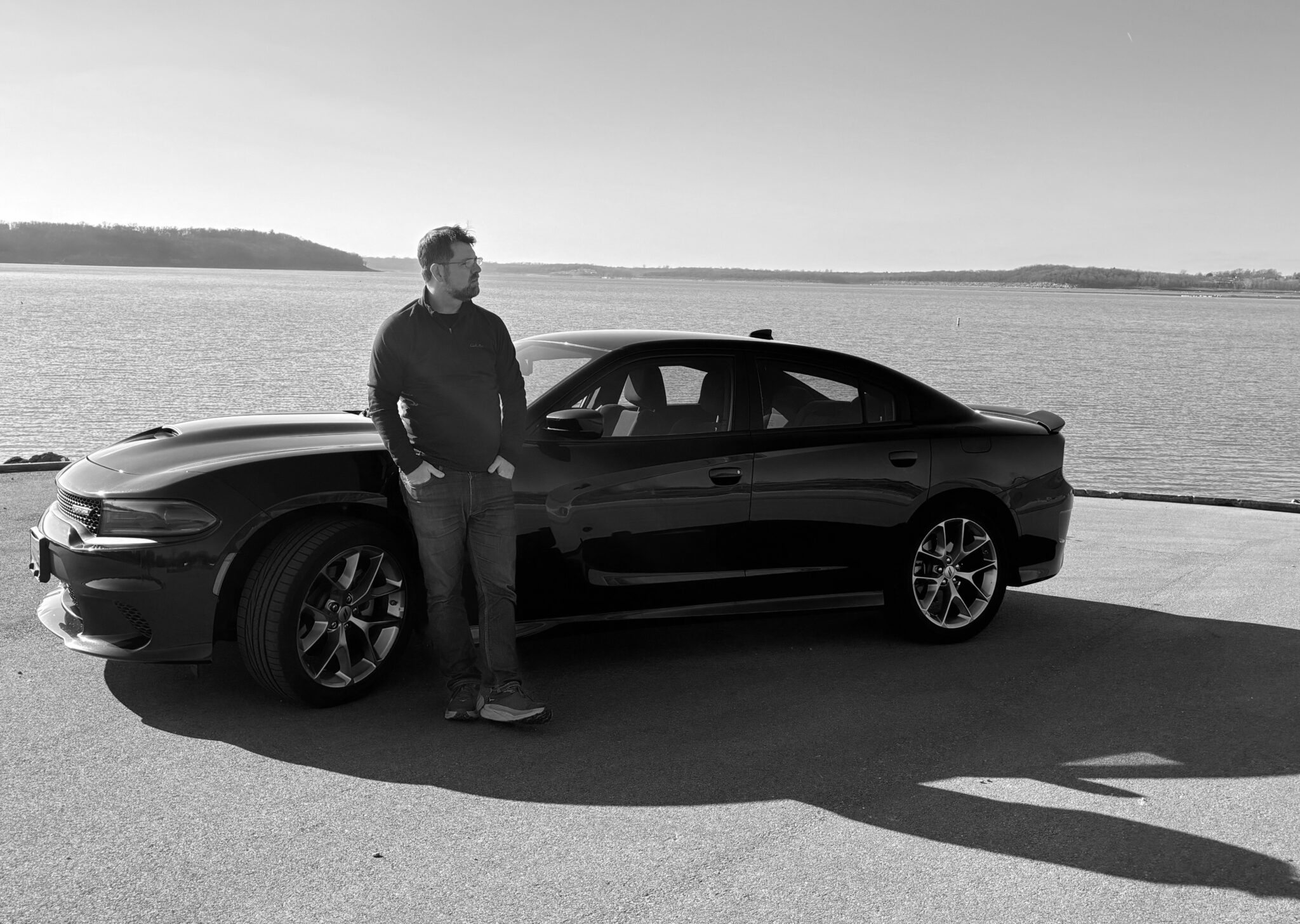 Chris Haulmark standing by a Dodge Charger near a serene lake